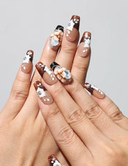 Model wearing Amber Bloom handmade Singapore press on nails with amber base and white floral designs