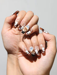 Amber Bloom classic nails style with amber gradient and white flower accents worn on hand