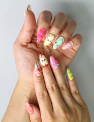 Close-up of cottagecore-inspired press-on nails featuring glossy apple accents, leafy details, and a playful 3D worm