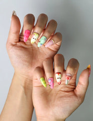 Side view of handmade Singapore nails in fresh fruit tones with tiny apple illustrations and nature-themed embellishments
