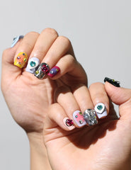 Hand posed to show vibrant coffin press on nails with colorful heart designs – naillover handmade nails