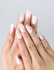 Hand gesture showing sheer base press on nails with white and pink floral art, handmade by Naillover in Singapore