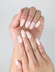 Close-up of delicate floral nail art on sheer press on nails in a natural soft shape by Naillover