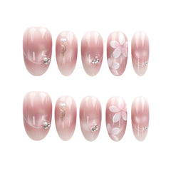 Blush Blossom Sparkle Singapore press on nails arranged on white background, showing pink translucent base, white flowers, and metallic details.