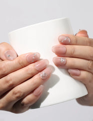 Model holding coffee cup while wearing Blush Gleam Cat Eye handmade Singapore press on nails with shimmering silver cat eye effect – naillover.