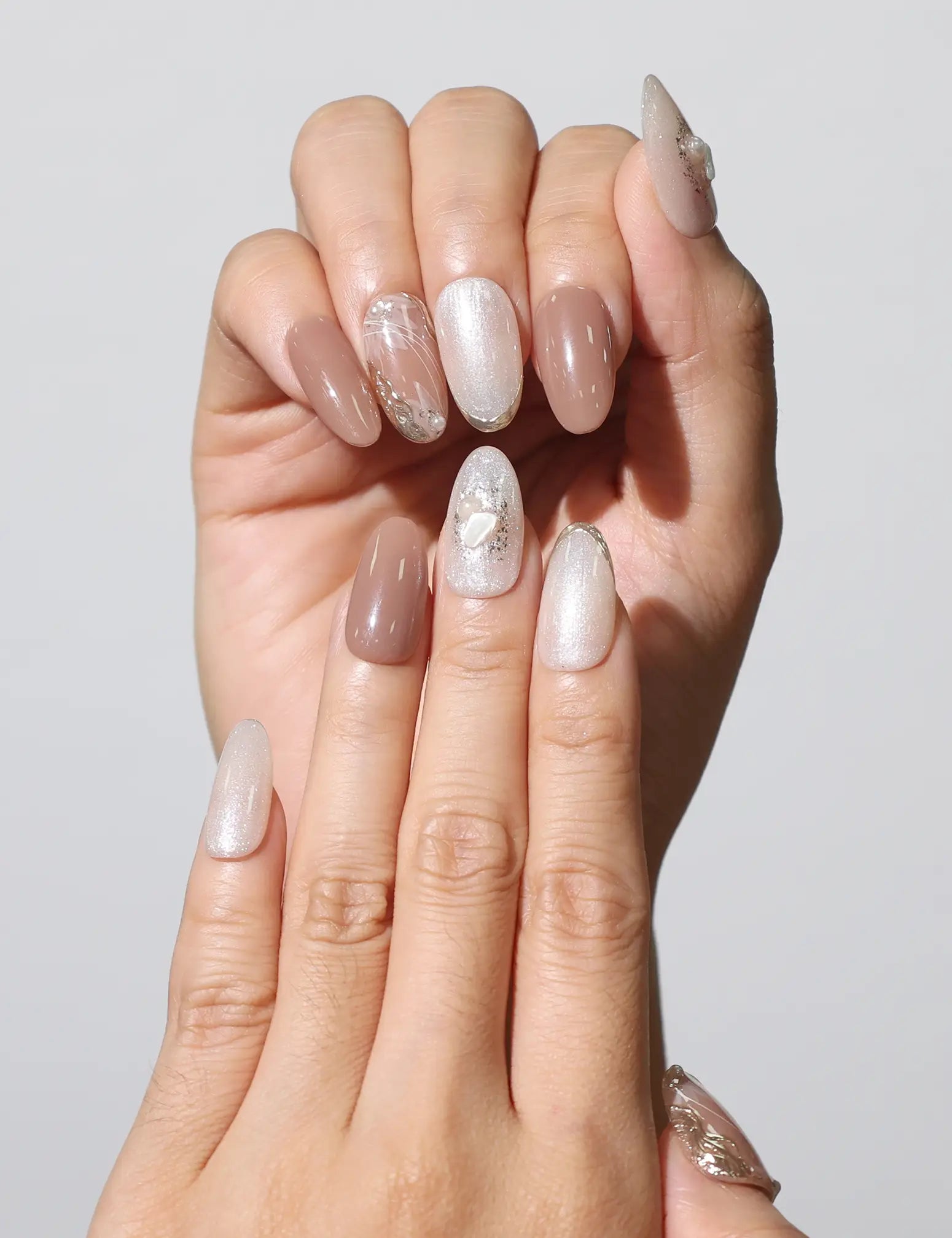 Close-up of fingers wearing Blush Pearl Gleam handmade press on nails with marbled brown design – naillover