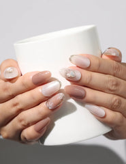 Hand holding a coffee cup while wearing Blush Pearl Gleam handmade press on nails – naillover