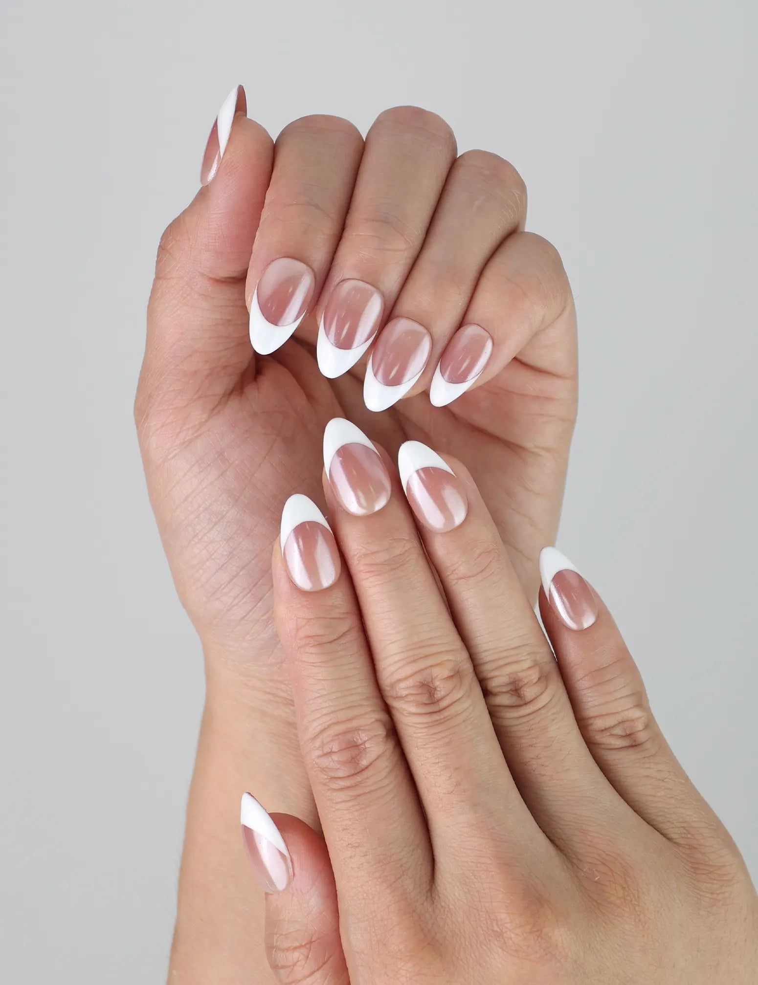 Close-up of Naillover’s handmade nails in a neutral taupe ombré blending into crisp white tips