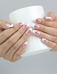 Hand holding a cup, showcasing Naillover’s short almond ombré nails in taupe and white for an elegant daily style