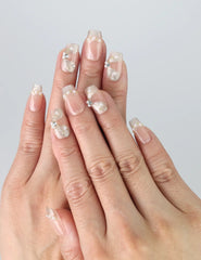 Hand model wearing Butterfly Grace Singapore press on nails with subtle floral embellishments