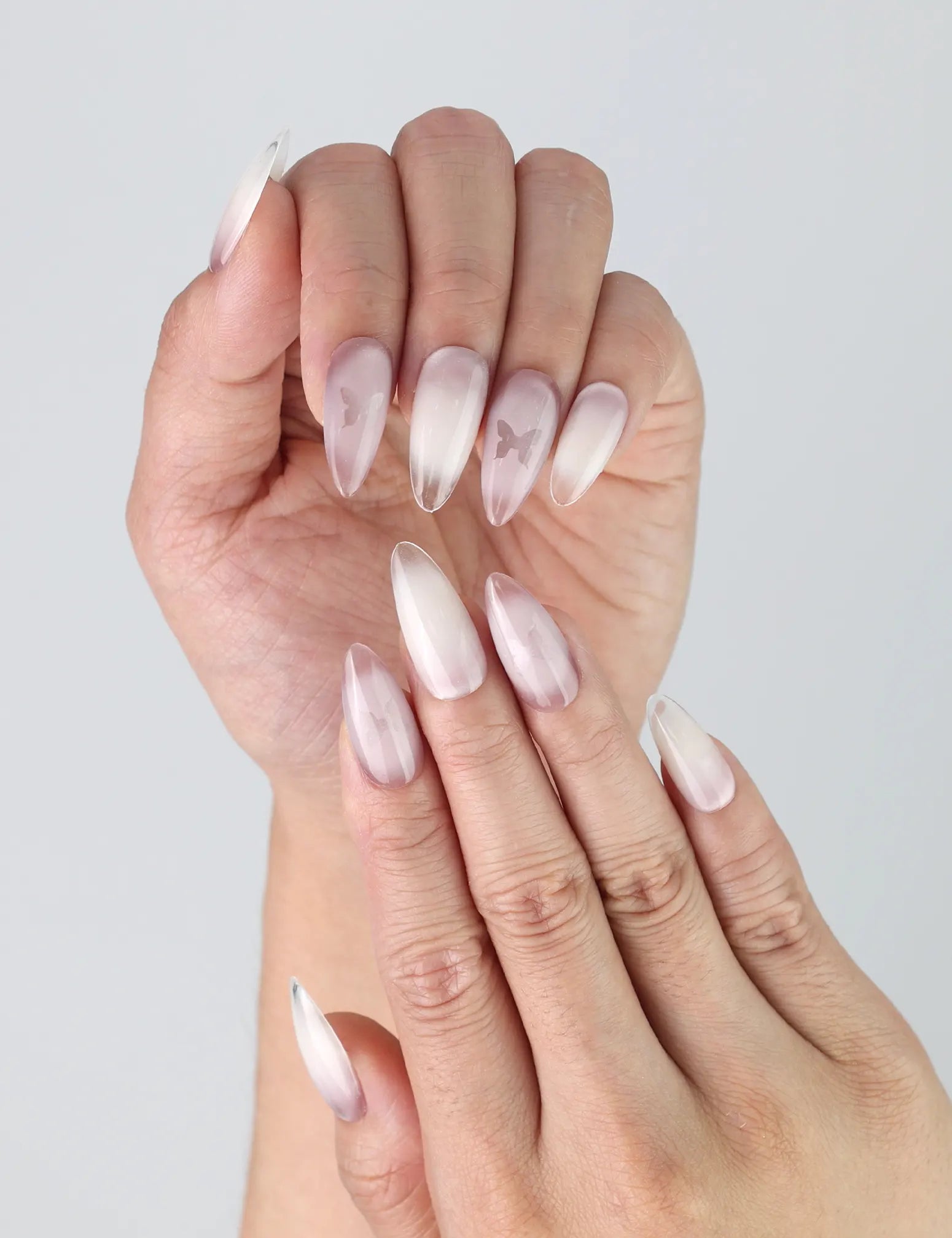 Close-up of Naillover’s handmade nails featuring romantic pink tones, subtle gradient, and 3D butterfly charms