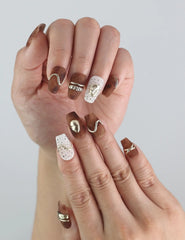 Close-up of fingers with Naillover Caramel Luxe Singapore press on nails, highlighting gold accents and coffin shape.