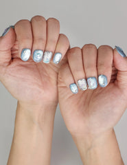 Naillover Celestial Blue handmade press on nails styled on hand with shimmering textures and glamorous details.