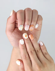 Fingers displayed with Singapore handmade press on nails featuring a blend of peach and seafoam shades and a subtle oceanic vibe