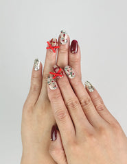 Hand wearing Crimson Bow handmade Singapore press on nails in red with white bows, perfect for festive parties