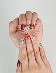 Close-up of Crimson Bow Singapore press on nails with elegant white bows and confetti accents on a vibrant red base