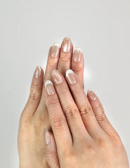 Model wearing Dewdrop Delight handmade Singapore press on nails with nude base and subtle shimmer