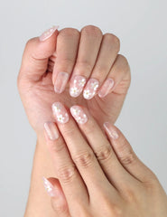 Close-up of Naillover’s handmade white flower nails featuring delicate layered blooms on a glossy base