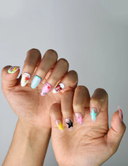 Side view of almond-shaped nails with glossy finish, pastel tones, and playful cat-and-star art