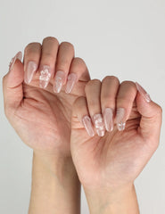 Floral Flicker Singapore press on nails with delicate flowers and crystals, worn for a whimsical and stylish manicure.