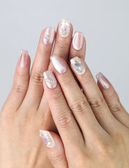 Hand gesture showing Flower Glint press on nails with pink-white glitter and 3D floral accents in soft pastel gradient by Naillover