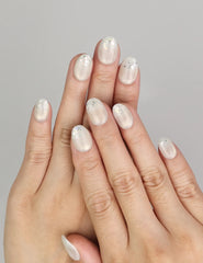 Hand wearing Naillover Frosty Glitter handmade press on nails with sheer base and silver glitter sparkle.