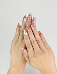 Hand wearing Glamorous nude Singapore press on nails with gold sequins, handmade by Naillover for a chic and classic nails look