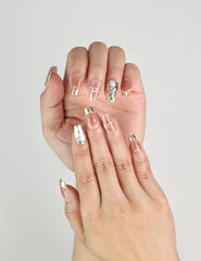 Fingers adorned with Glamorous nude and gold sequined Singapore press on nails, elegant handmade design by Naillover