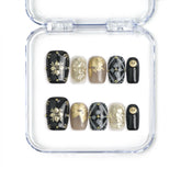 Singapore handmade black press on nails with white and gold floral nail art, golden leaves, and rhinestone details by Naillover