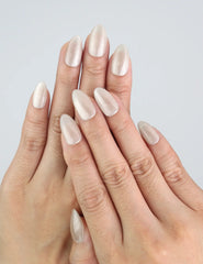 Hand wearing Glimmer Dust press on nails by Naillover, showing golden shimmer on cream base in almond shape.