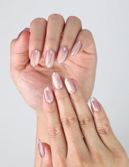 Close-up of Naillover’s short mauve pink nails with subtle chrome effect and crystal embellishments
