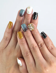 Model wearing Naillover Golden Bloom press on nails with golden 3D flower, soft ivory base, and brown gradient accents.