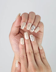 Close-up of Naillover’s handmade Singapore nails featuring a creamy ivory base with delicate silver foil accents