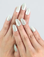 Model wearing Naillover Jade Curve press on nails in jade green with elegant cat eye shimmer.