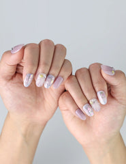 Close-up of hands with gradient press on nails in lavender, pink, and white tones, featuring iridescent highlights by Naillover
