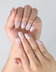 Fingers shown wearing Singapore handmade pink nails adorned with subtle flower art and sparkling rhinestones