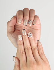 Close-up of Naillover Midnight Bow handmade Singapore press on nails, short length, beige-black with metallic ribbon details