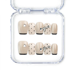 Naillover Midnight Bow handmade Singapore press on nails in beige and black with dots and metallic silver ribbons, short length