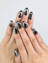 Model hand wearing Naillover’s Midnight Gaze black press on nails with cat eye shimmer.