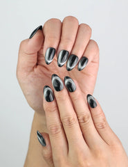 Close-up of Midnight Gaze handmade press on nails in sleek black, featuring soft magnetic glow.