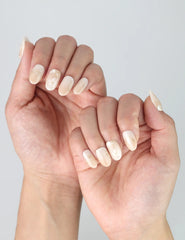 Side view of minimalist short oval nails with glossy greige polish and subtle gold sparkle
