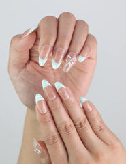Hand wearing Naillover Mint Chic Singapore press on nails resting on fabric, highlighting the subtle gradient design.