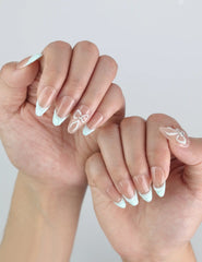 Side angle of fingers with Naillover Mint Chic handmade press on nails, featuring coquette-style bows and a glossy finish.