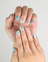 Close-up of Mint Frost handmade blue shimmer press on nails with crystals and bow, worn on hand, naillover Singapore