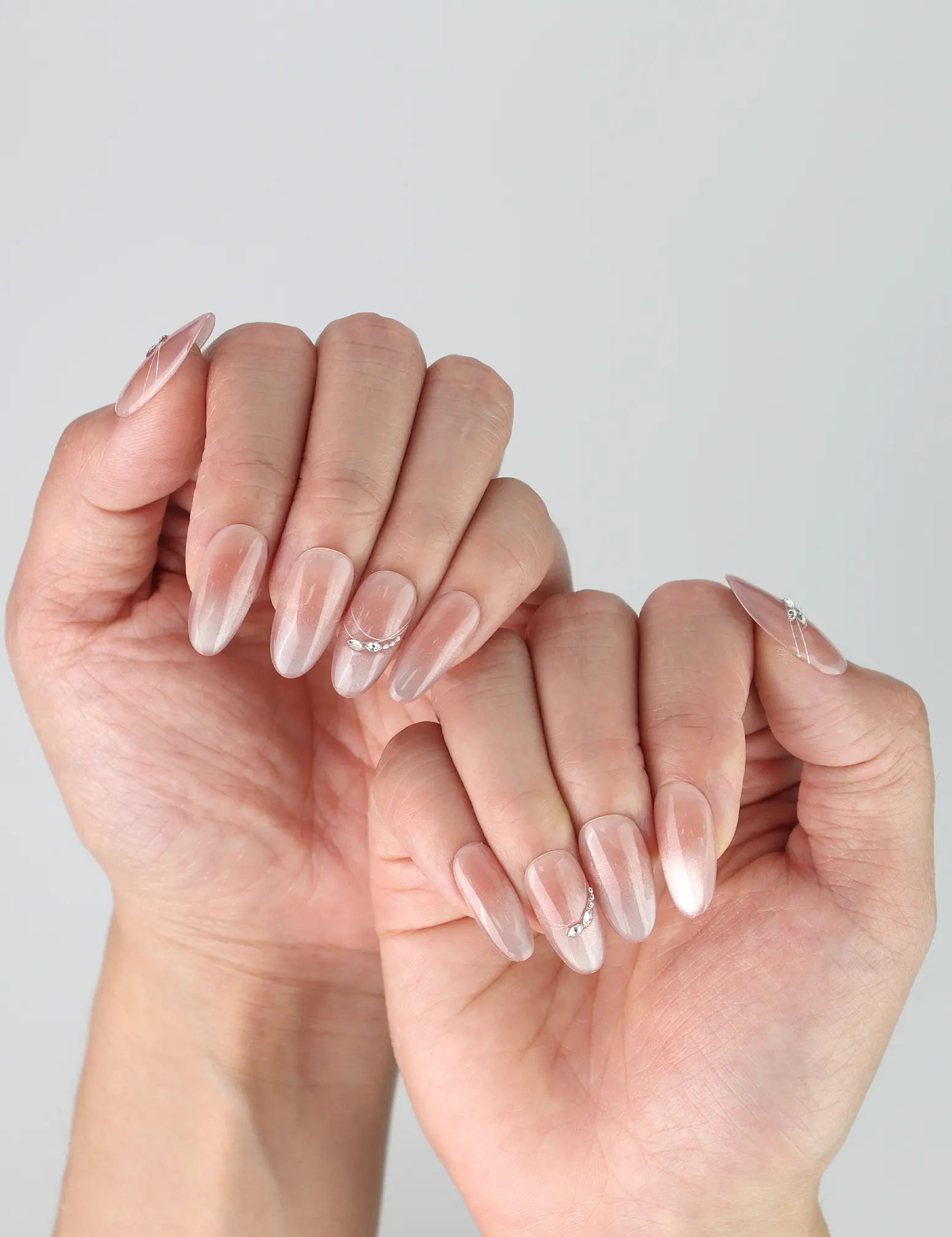 Side view of romantic press-on nails with gradient shimmer base and dimensional silver blooms