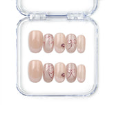 Naillover handmade press on nails in nude with French tips, champagne heart and bow accents, from Singapore press on nails collection.