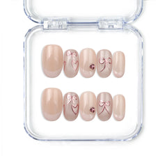 Naillover handmade press on nails in nude with French tips, champagne heart and bow accents, from Singapore press on nails collection.