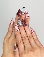 Naillover Blush Enigma trendy press on nails worn on hand, showcasing burgundy and white with floral accents.