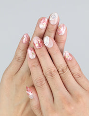 Wearing Naillover Blush Gold press on nails—blush pink base with gold foil and seashells for a summer-ready look.