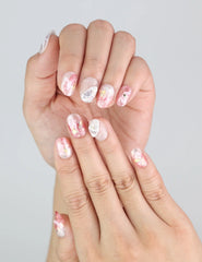 Close-up of Blush Gold handmade press on nails with marbled pink tones and delicate 3D summer accents.